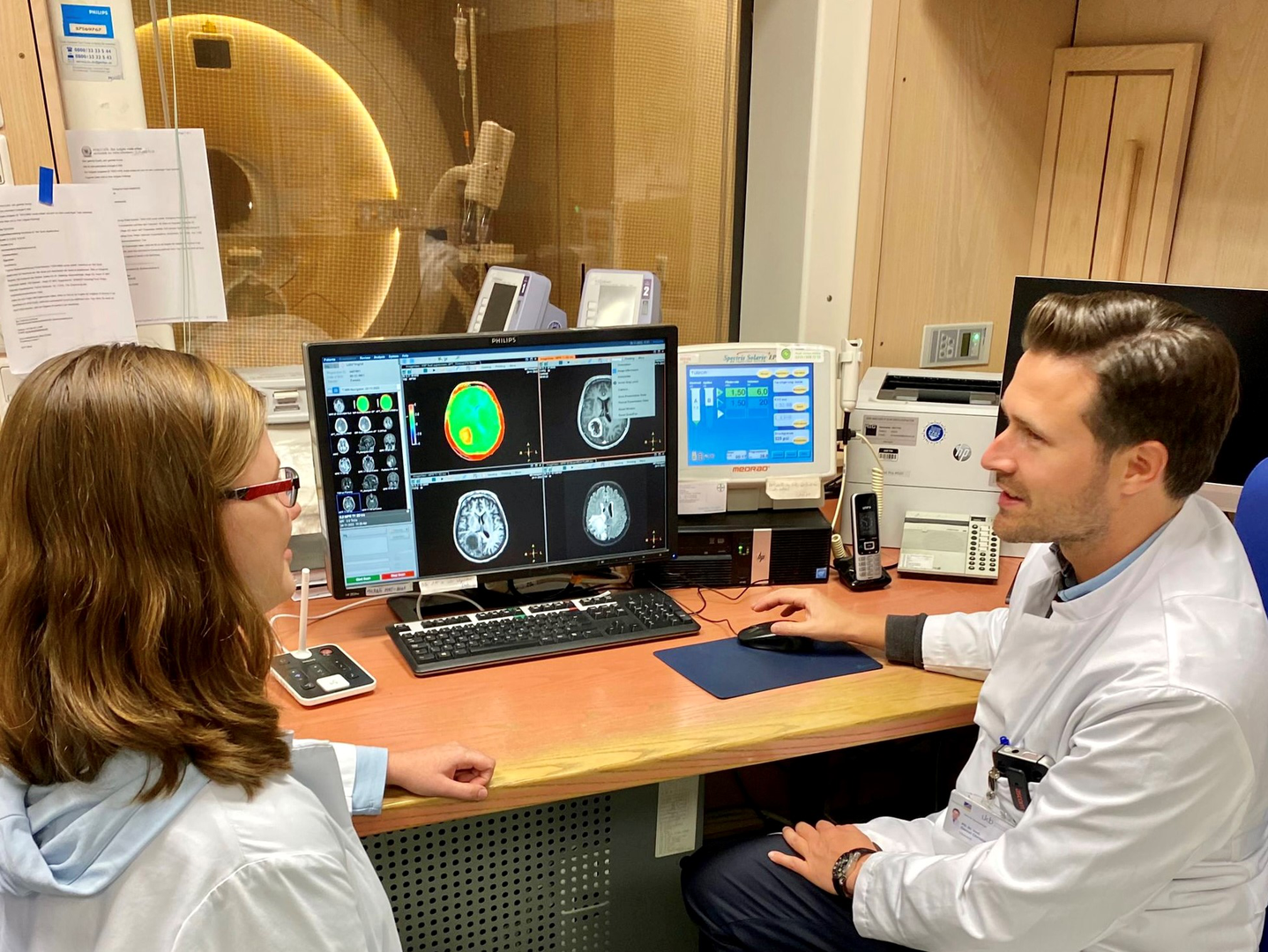 Im Gespräch - Privatdozent Dr. Daniel Paech und die Doktorandin Inga Krause diskutieren MRT-Aufnahmen eines Patienten mit Hirntumor.