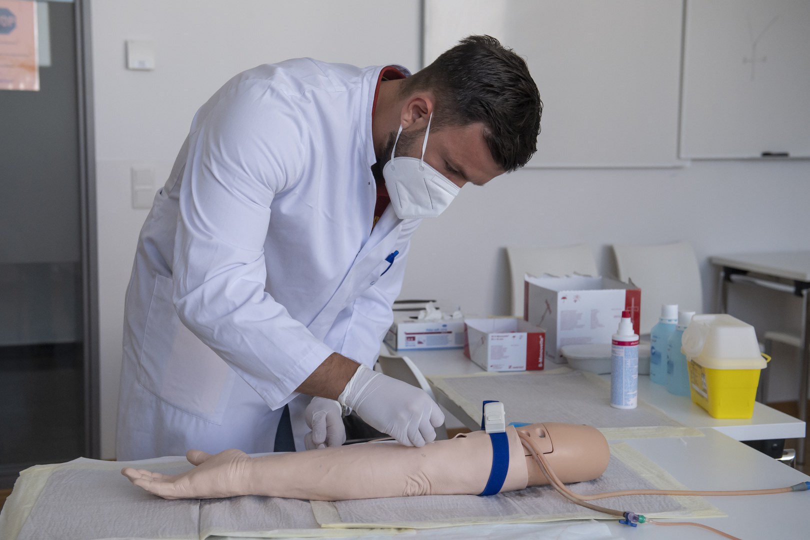 Ein Medizinstudent untersucht während der Prüfung einen Arm