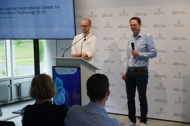 Dr. Jonas Henn (BOSTER) und Prof. Holger Fröhlich (b-it) begrüßen die Teilnehmenden beim #Hack4Surgery