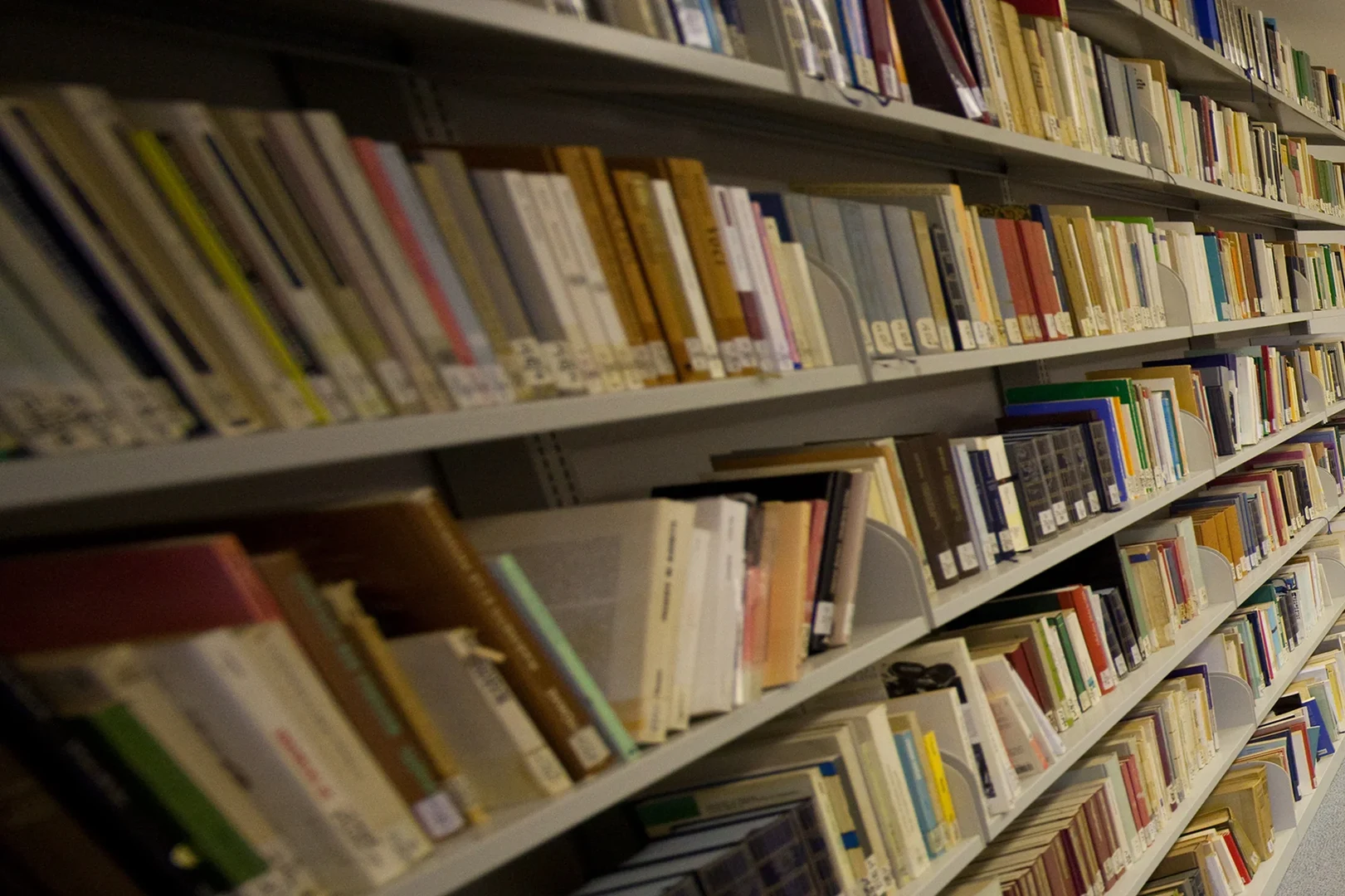 Eine Wissenschaftlerin und ein Wissenschaftler arbeiten hinter einer Glasfassade und mischen Chemikalien mit Großgeräten.