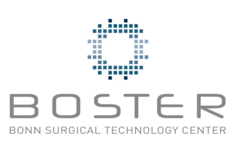 Eine Wissenschaftlerin und ein Wissenschaftler arbeiten hinter einer Glasfassade und mischen Chemikalien mit Großgeräten.