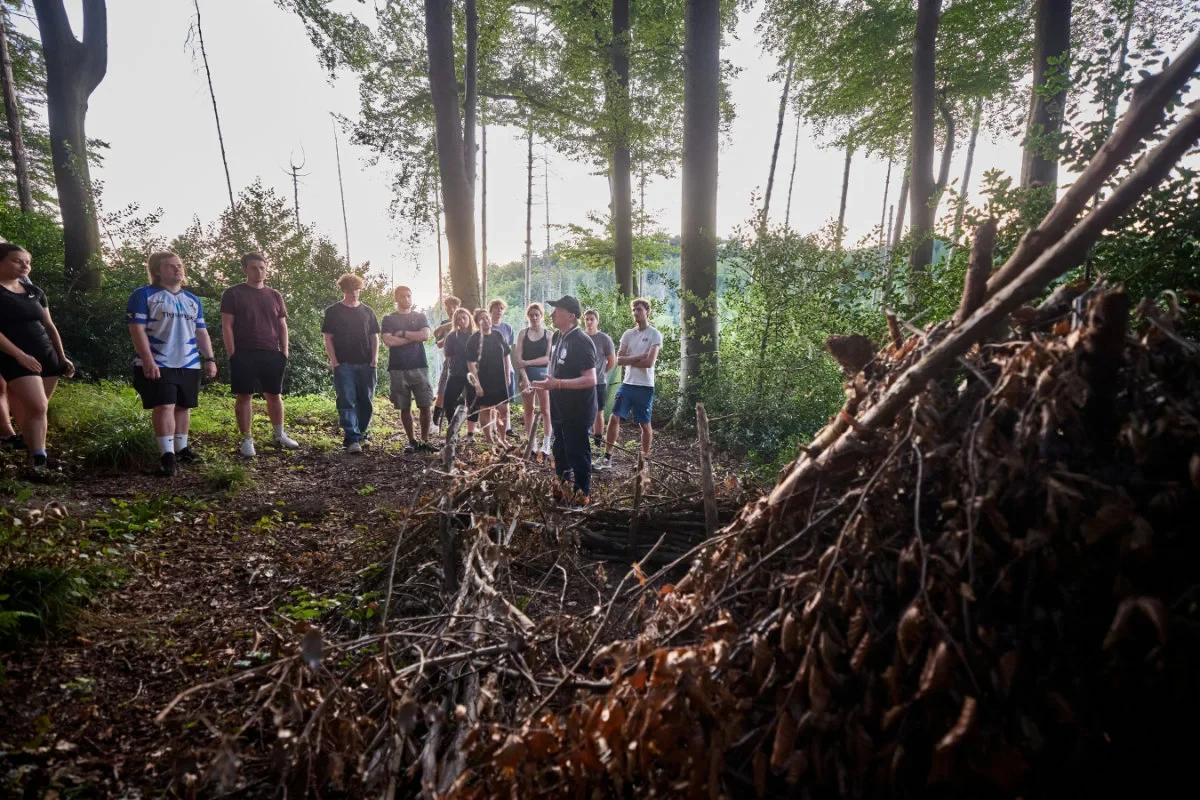 Out in the forest, - Joey Kelly showed the young doctors how to build a lean-to out of branches.